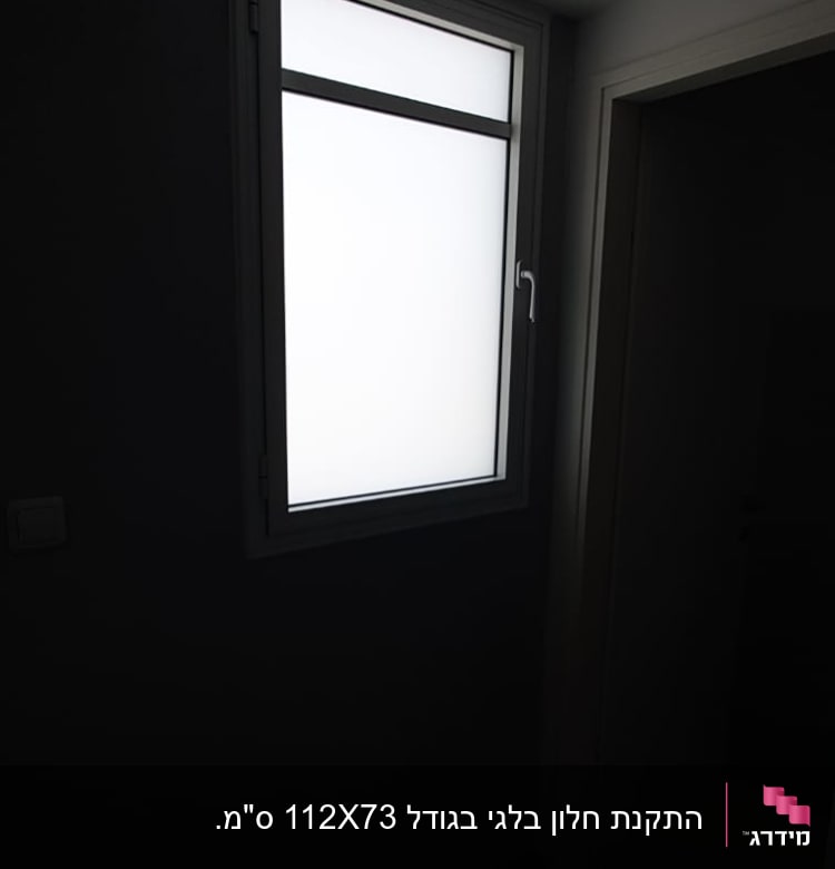 חלון עם מסגרת אלומיניום וקיר כהה